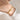 Gold-tone curved bar bracelet with an engraved plate worn on a wrist