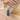 バッグと手のそばに置いた青い楕円形の刻印キーホルダー