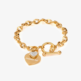 Pulsera con cierre toggle y dije de corazón en tono dorado, con ejemplo de grabado