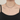 Collar plateado de capas con dije de barra con una blusa de satén negra