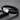 Pulsera trenzada negra con cierre grabado tono plateado sobre una superficie oscura