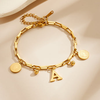 Gold paperclip chain bracelet with letter A charm, round coin charms and bead charms