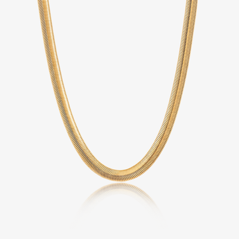 Collar de cadena plana dorado sobre fondo claro