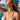 Woman in a white top wearing a gold-tone heart toggle necklace by the sea