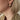 Close-up of an ear wearing a gold-tone ribbed triple hoop earring