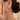 Silver-tone large hoop earring worn on an ear with a small stud above, hand near the face