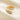 gold-tone open wrap ring with white marbled inlay resting on cream fabric