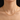 Gold-tone paperclip chain necklace worn above a black neckline