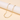 Gold-tone paperclip chain necklace draped on a pale display