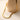 Gold-tone Cuban chain necklace resting on a beige vase