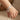 Silver-tone curved bar bracelet with a crown charm worn on a child's wrist