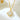 Close-up of a gold-tone four-leaf clover pendant with a clear faceted center on white marble