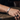 Hombre con una pulsera de cadena personalizada con grabado en tono plateado en la muñeca