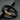 Pulsera trenzada negra con cierre tono dorado grabado con LOVE YOU sobre una superficie oscura