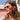 Woman in sunglasses wearing a gold-tone twisted hoop earring outdoors