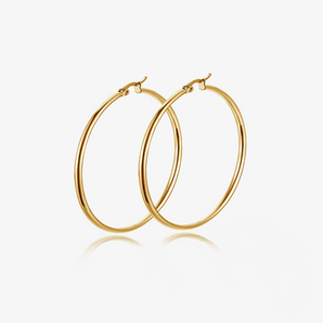 Gold-tone large round titanium steel hoop earrings pair on light grey background