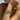 Woman wearing several layered strand bracelets with leaf-shaped beads on wrist at the beach