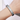 Primer plano de una pulsera de silicona grabada personalizada con placa metálica en la muñeca