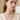 Silver-tone round stone pendant and earrings worn with a light top